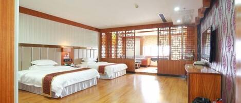 A hotel room with two beds, a desk, a TV, and a traditional decorative screen.