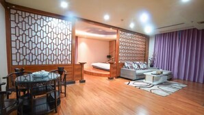 A modern living room with a round dining table, a sofa, and a decorative partition. - Shibazi Hotel (Yangjiang)