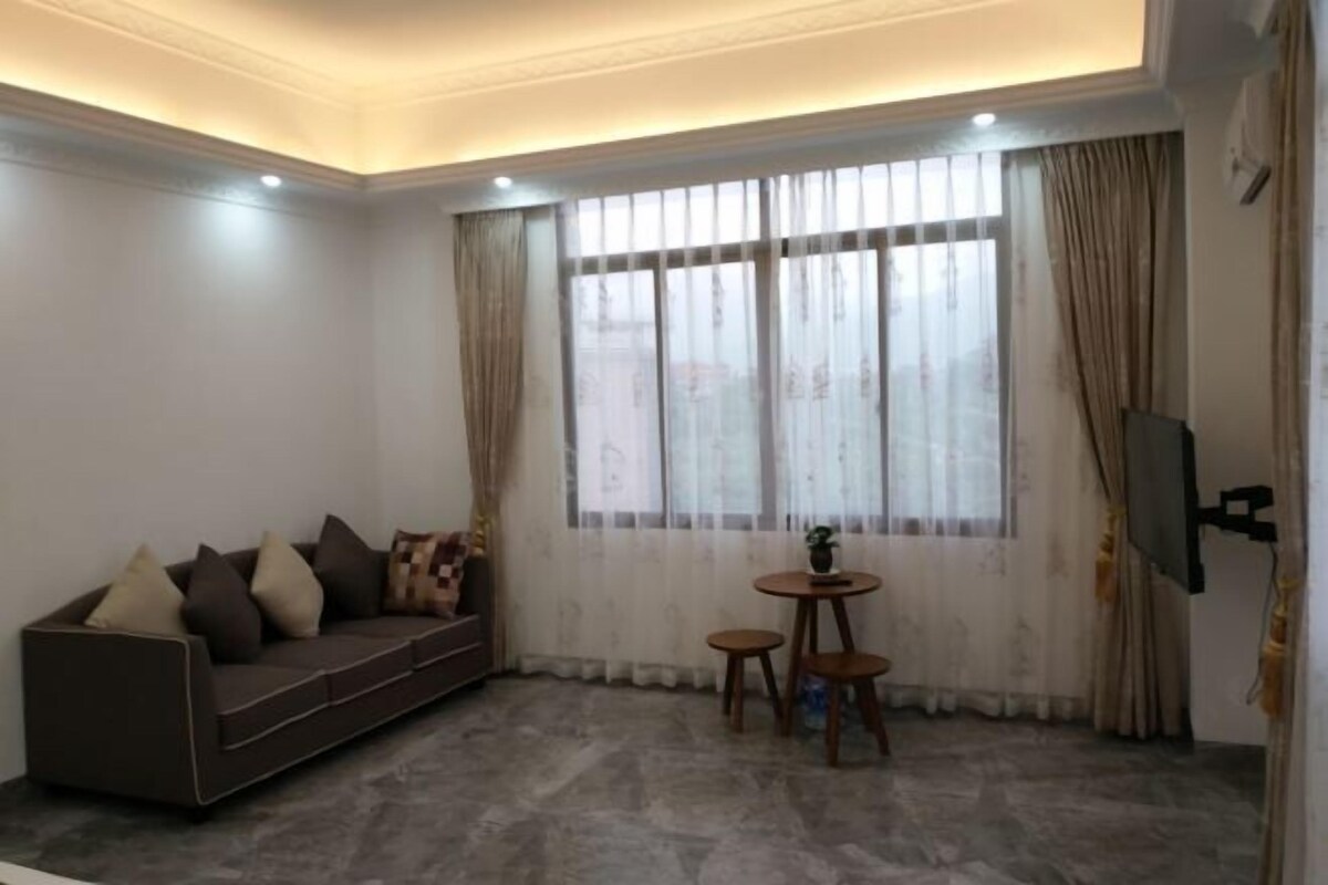 A living room with a sofa, a small table, and a TV.