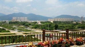 A cityscape with a park, a monument, and residential buildings. - Tangquan Mingwu Hostel (Xiamen)
