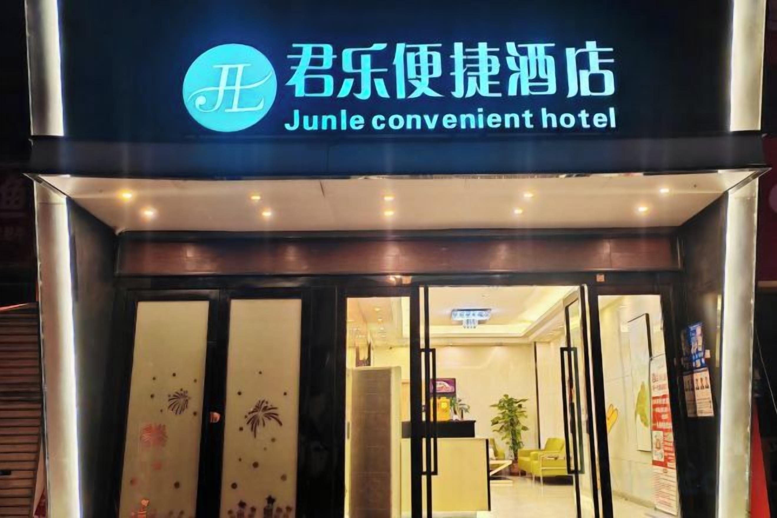 Entrada do hotel Junle, com porta de vidro e placa acima.