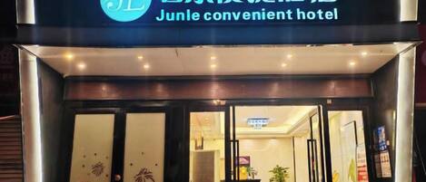 L'ingresso dell'hotel Junle, comodo, con una porta in vetro e un cartello sopra.