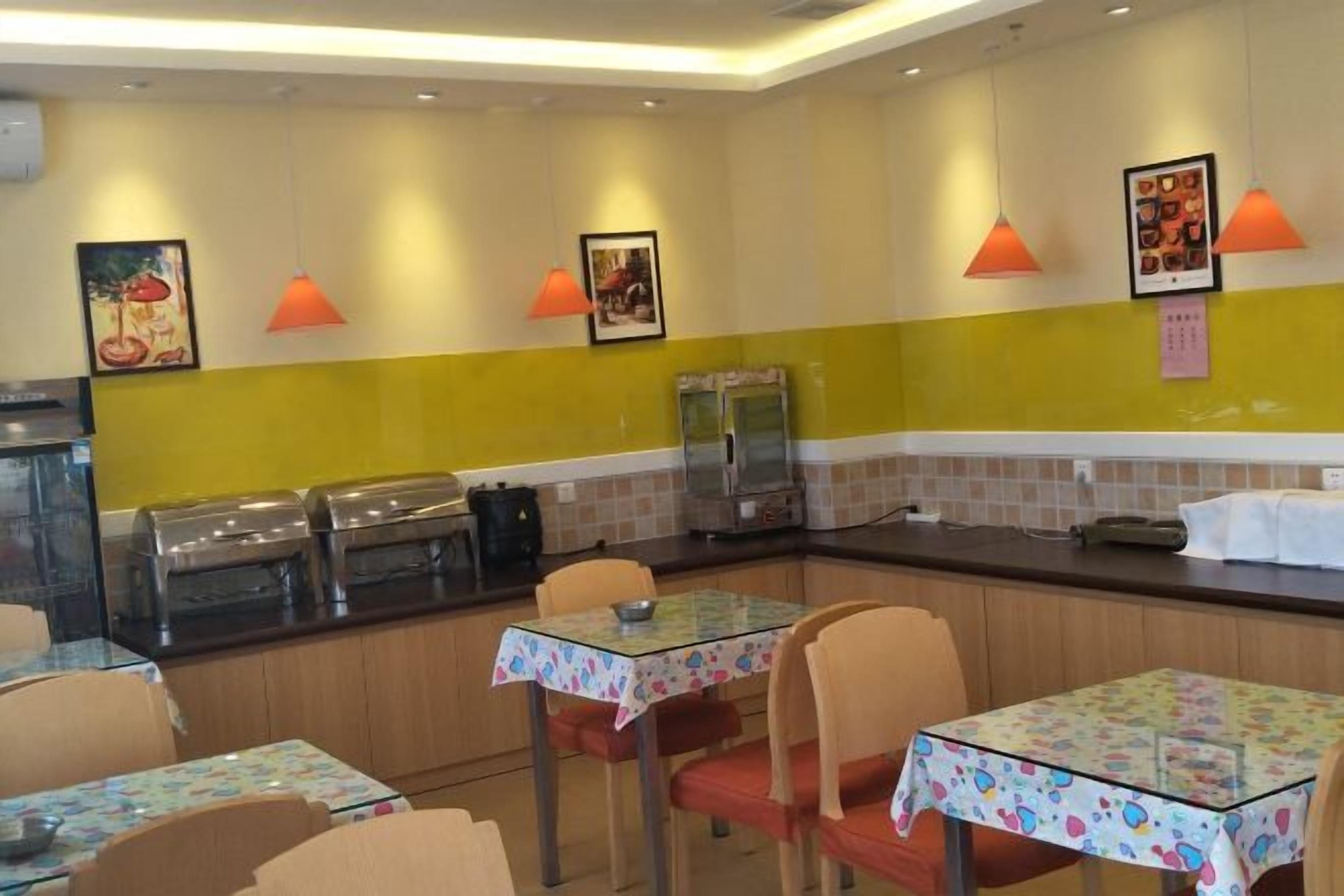 A restaurant interior with tables, chairs, and a counter with food display.