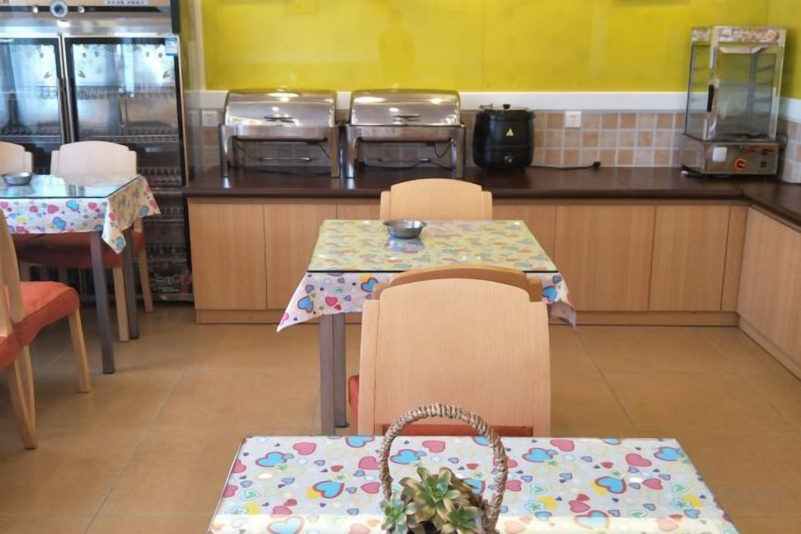 A kitchen with a dining table, chairs, and a buffet area.