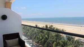 Un balcon avec vue sur une plage et des palmiers.
