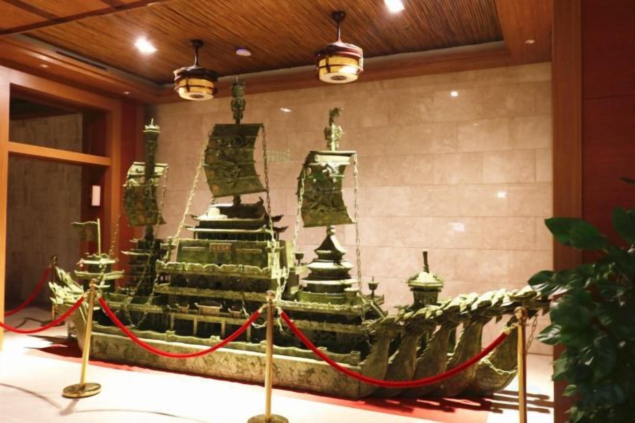 A ship-shaped exhibit with multiple levels and a red rope barrier.