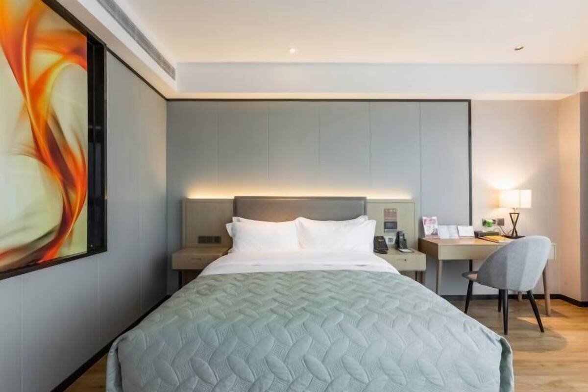 Ein Hotelzimmer mit Bett, Schreibtisch und Stuhl.