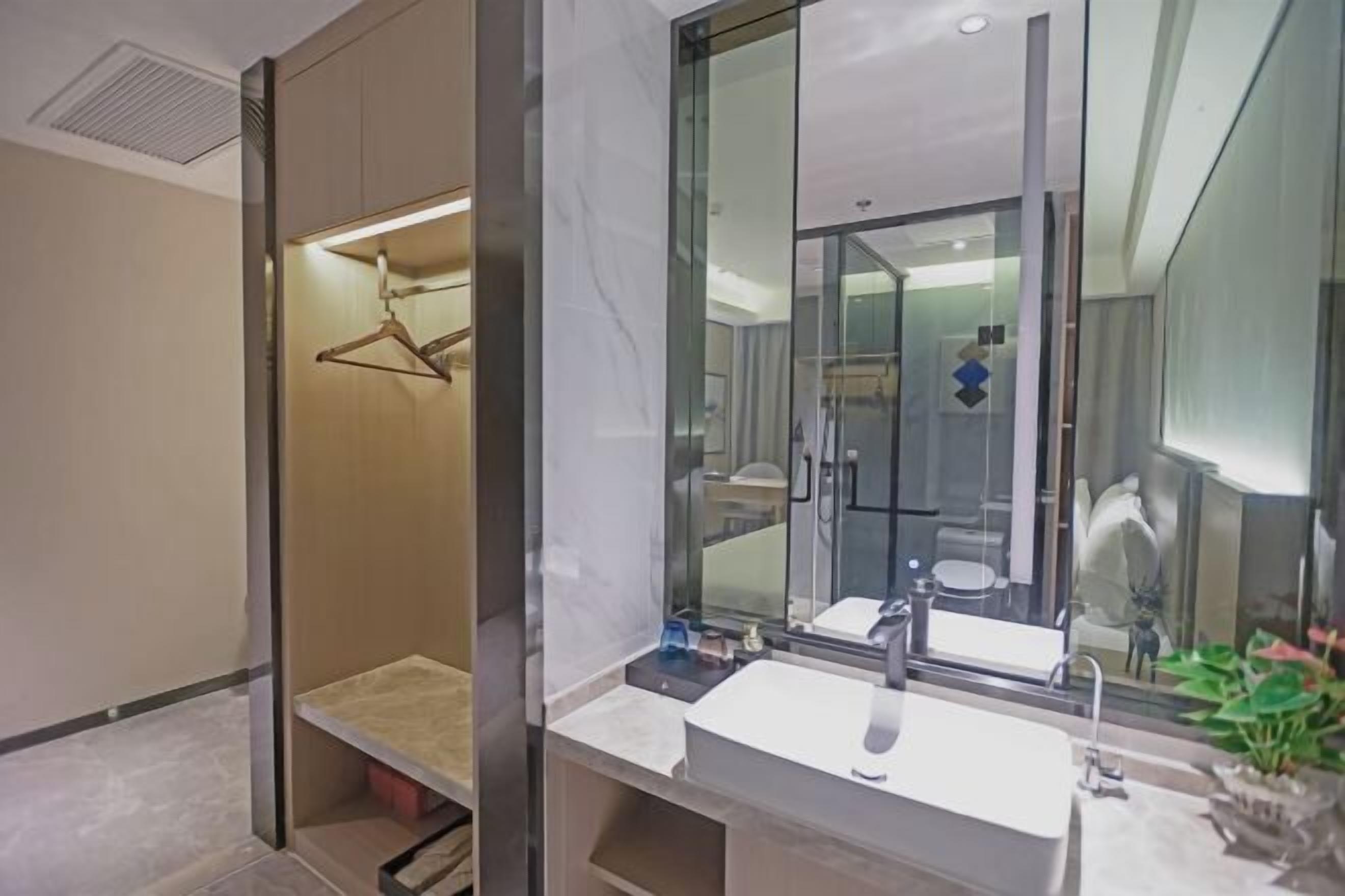 A modern bathroom with a large mirror, a sink, and a shower area.
