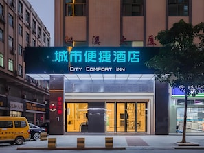 Un edificio con un letrero que dice 'City Comfort Inn' y una entrada moderna.