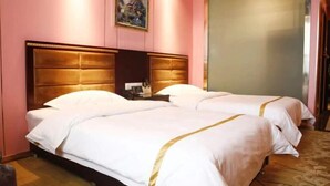 Une chambre d’hôtel avec deux lits, une tête de lit en bois, un tableau au mur et une grande fenêtre.