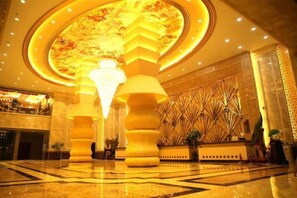 A lobby with a large chandelier, a reception desk, and a decorative wall. - Duxiu Hotel (Tacheng City)