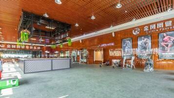 Un gimnasio amplio con equipo de ejercicio, un mostrador de recepción y carteles motivacionales en las paredes.