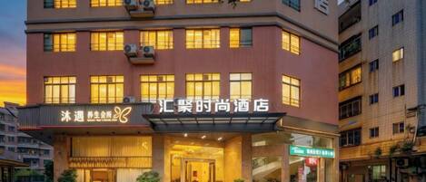 A hotel with a modern facade, multiple windows, and a visible entrance.