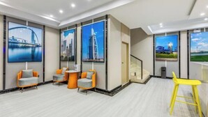 A modern hotel lobby with large windows, seating areas, and artwork depicting cityscapes. - City Youpin Hotel (Wuhan Zuoling New City) (Wuhan)
