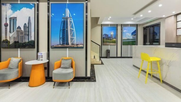 A modern hotel lobby with a reception desk, seating area with chairs, and large cityscape murals on the walls. - City Youpin Hotel (Wuhan Zuoling New City) (Wuhan)