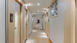 A long, narrow hotel corridor with doors on both sides, a patterned floor, and a ceiling with recessed lighting. - City Youpin Hotel (Wuhan Zuoling New City) (Wuhan)