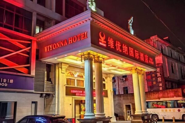 The exterior of the Viyonna Hotel with illuminated signage and classical architectural columns.