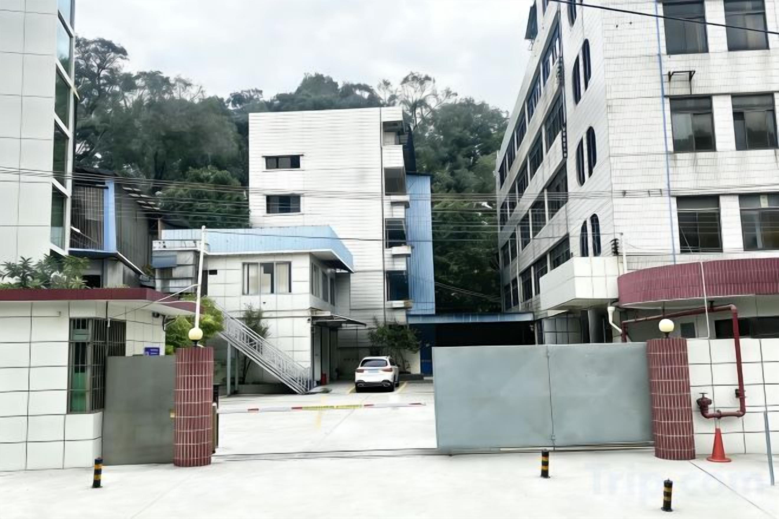 A gated entrance to a building with a staircase leading up to a parking area.