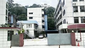 A gated entrance to a building with a staircase leading up to a parking area.
