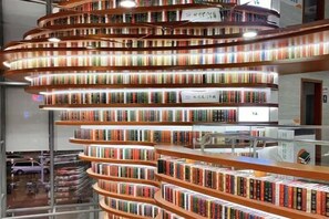 A spiral staircase bookshelf with multiple levels of books. - Ubay Hotel (Xiamen)