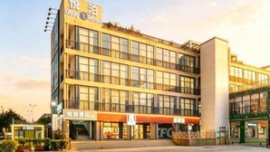 A multi-story hotel with a modern design, featuring a prominent entrance, multiple windows, and a visible signboard. - Ubay Hotel (Xiamen)