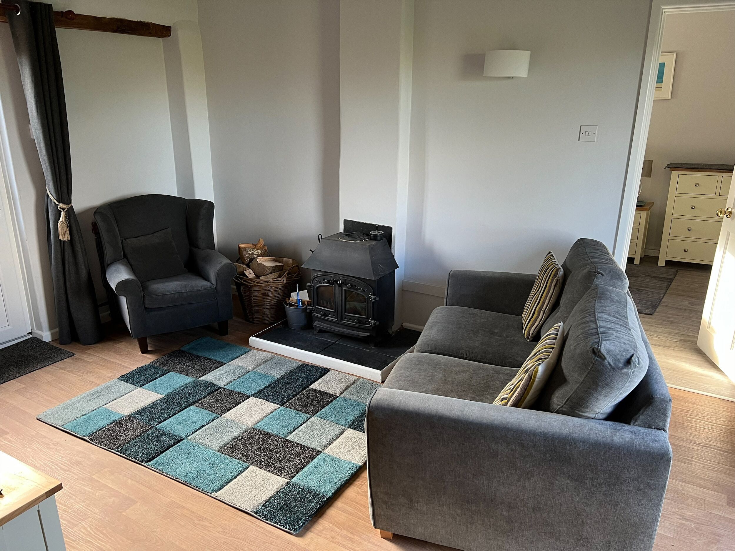 Un salon avec un canapé, un fauteuil et une cheminée.