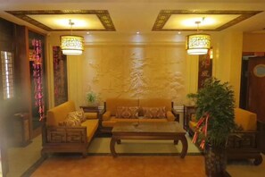 A traditional-style living room with a sofa set, a coffee table, and decorative wall art. - Lavande Hotel (Longnan Changjiang Avenue) (Longnan)