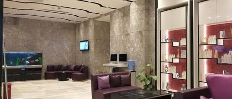 A modern lobby with a reception desk, seating area, and a large aquarium.