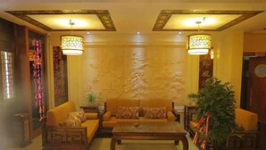 A traditional-style living room with a sofa set, a coffee table, and two hanging lamps. - Lavande Hotel (Longnan Changjiang Avenue) (Longnan)