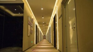 A hotel corridor with doors on both sides, recessed lighting, and a carpeted floor. - Lavande Hotel (Longnan Changjiang Avenue) (Longnan)