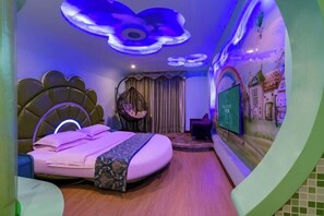 Un dormitorio con diseño moderno, que incluye una cama con cabecera original, una silla colgante y una pared con un mural.