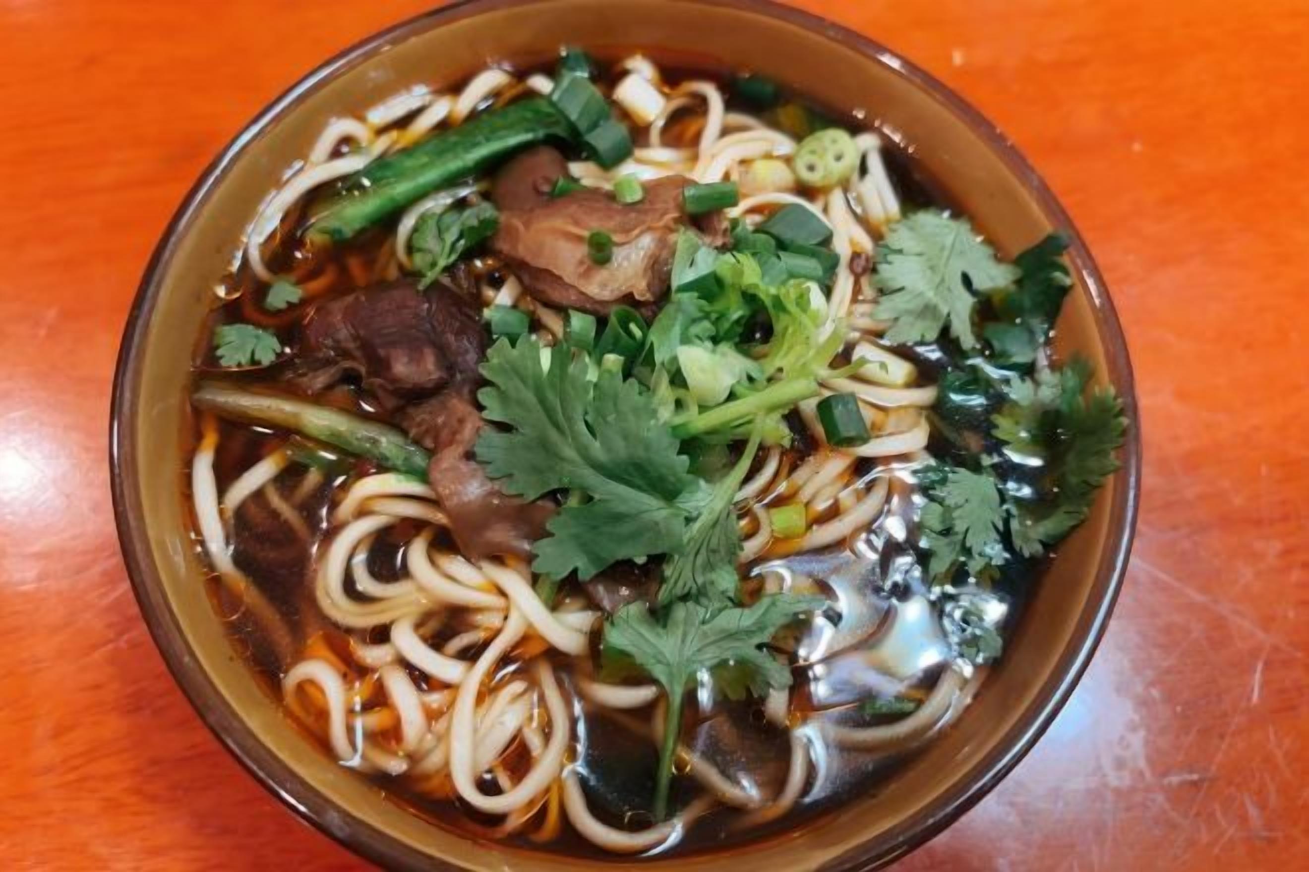 Un tazón de sopa de fideos con diversos ingredientes.