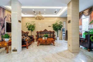 Un salón amplio con un sofá grande, una mesa de centro y dos plantas en macetas.