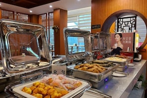 A buffet area with multiple food stations and a sign with a person's image. - Valatoms Fanlatu Hotel (Shuifu Municipal Government) (Shuifu)