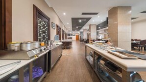Una cocina moderna con electrodomésticos de acero inoxidable, una isla central con un lavabo y una encimera larga con alimentos.