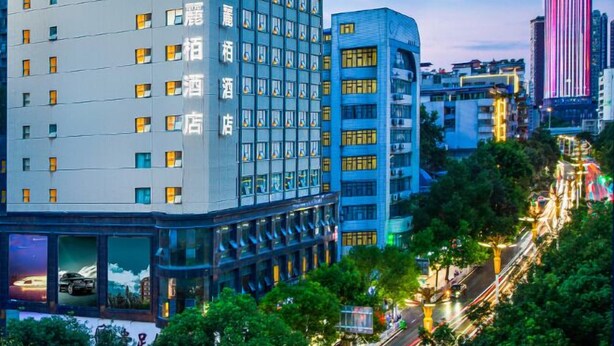 Un hotel con fachada moderna, varios pisos y señalización llamativa.