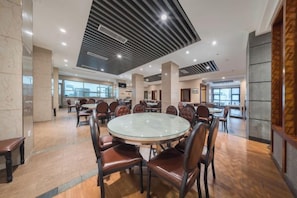 A spacious dining area with round tables and chairs, a modern ceiling design, and large windows providing natural light. - Zunyi Hotel (Zunyi Conference Site) (Zunyi)