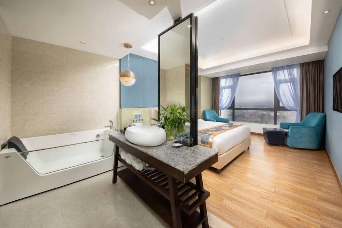 A modern bathroom with a bathtub, a vanity, and a large mirror.
