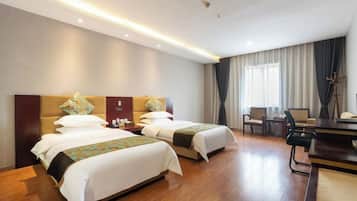 A hotel room with two beds, a desk, a chair, and a large window with curtains.