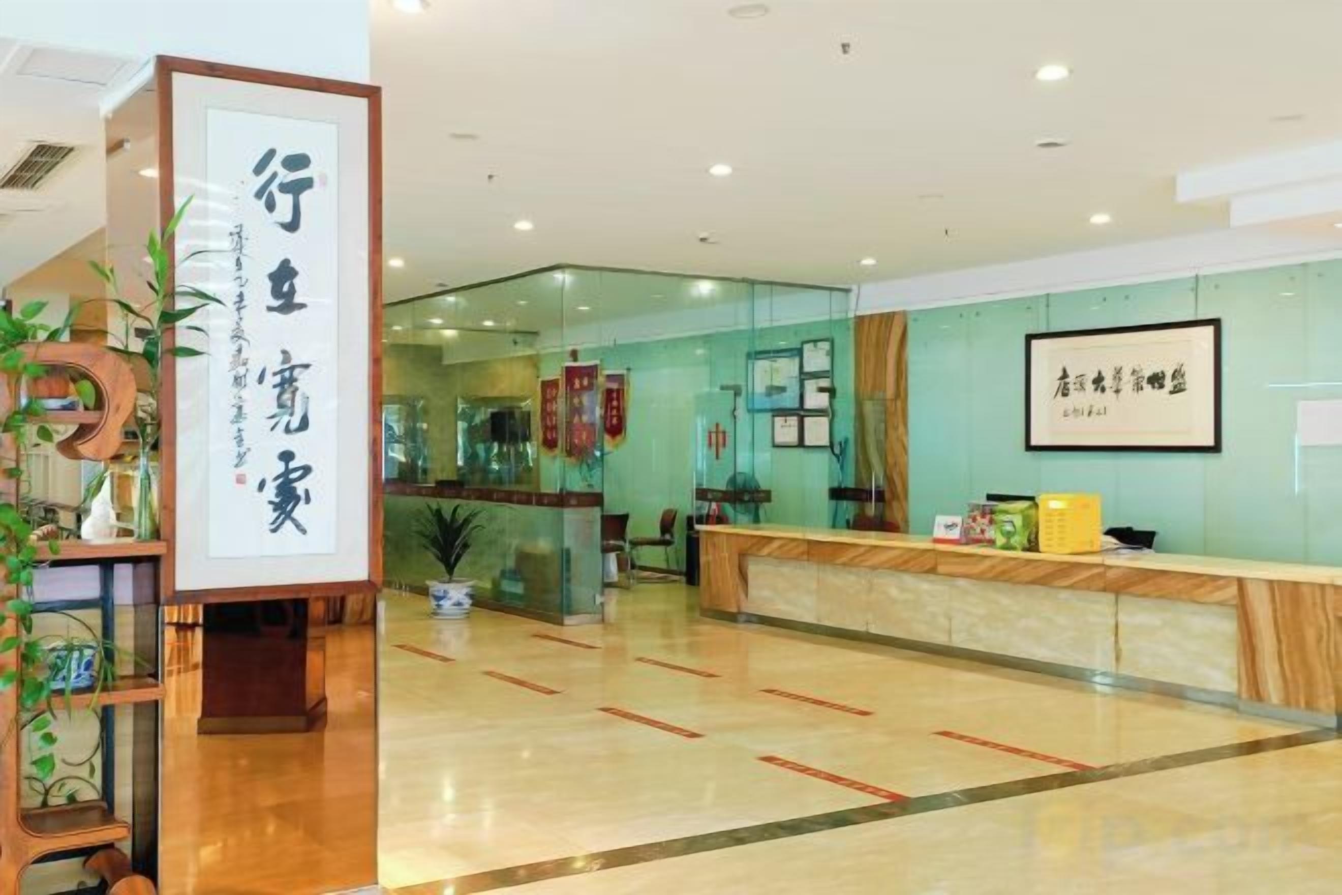 A reception area with a reception desk, a sign with Chinese characters, and a plant.