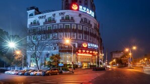 Un hotel con un letrero llamativo y una entrada bien iluminada.