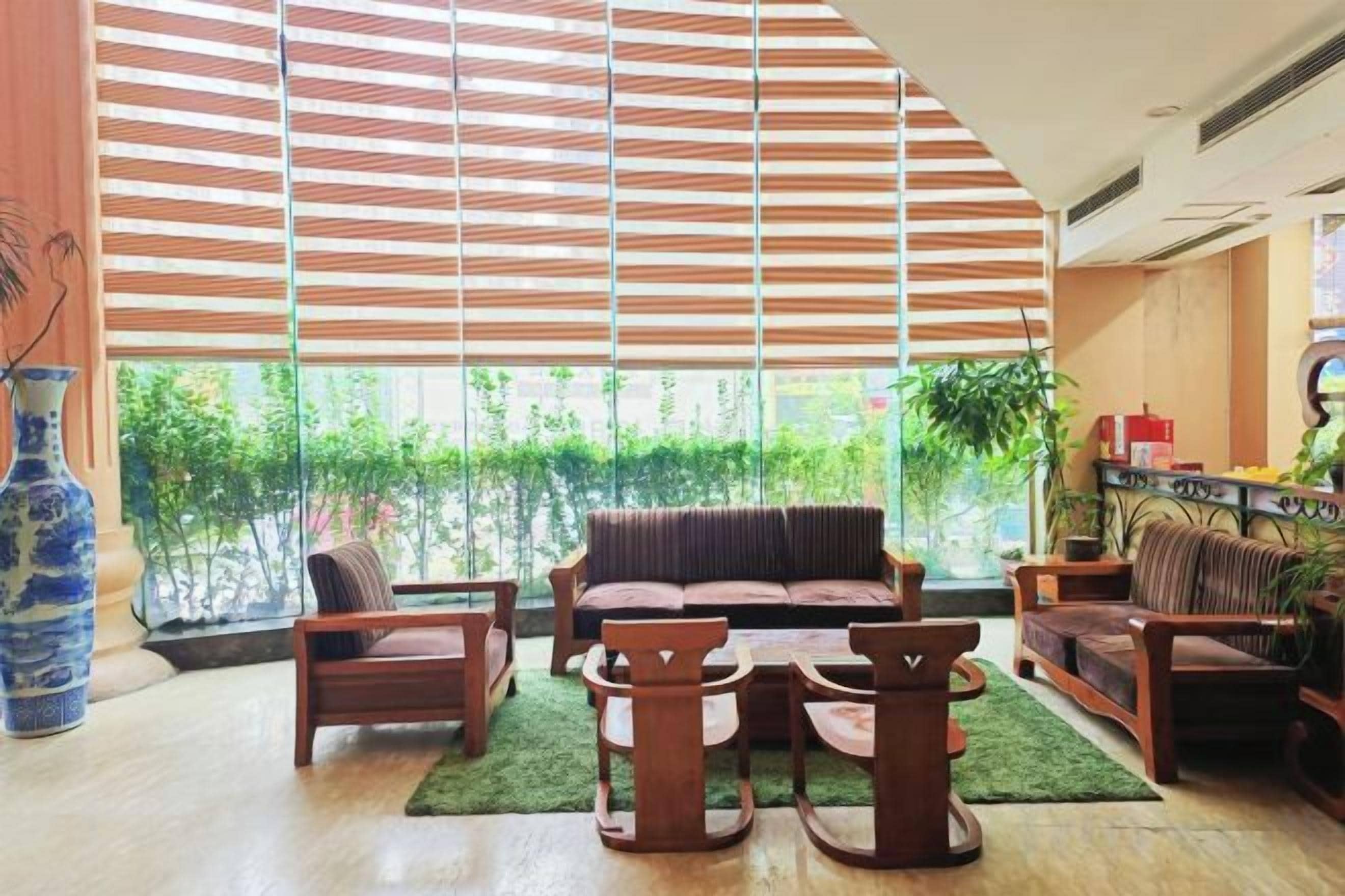 A spacious living area with a large window, a sofa, a coffee table, and a bookshelf.
