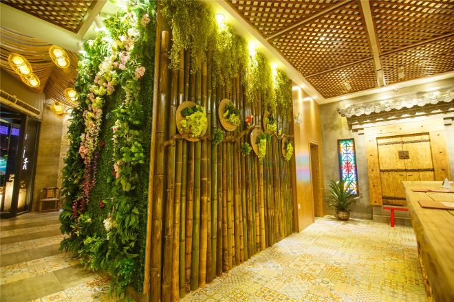 A reception area with a vertical garden, wooden panel wall, and a patterned floor.
