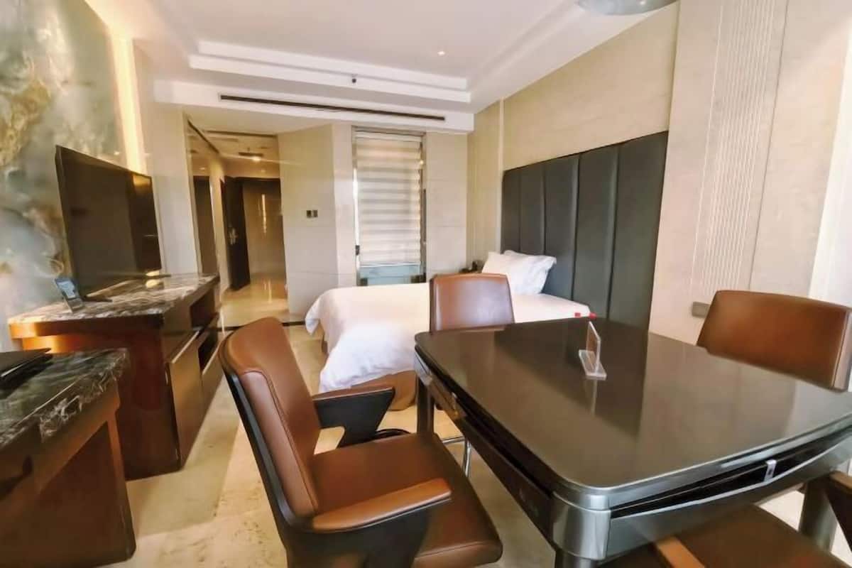 Une chambre d’hôtel moderne équipée d’un lit, d’une table à manger, d’un téléviseur et d’un coin salon.