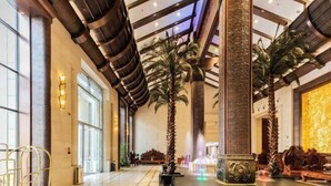 A spacious lobby with high ceilings, large windows, and palm trees. - Apollo Regalia Hotel & Resort (Yueyang)