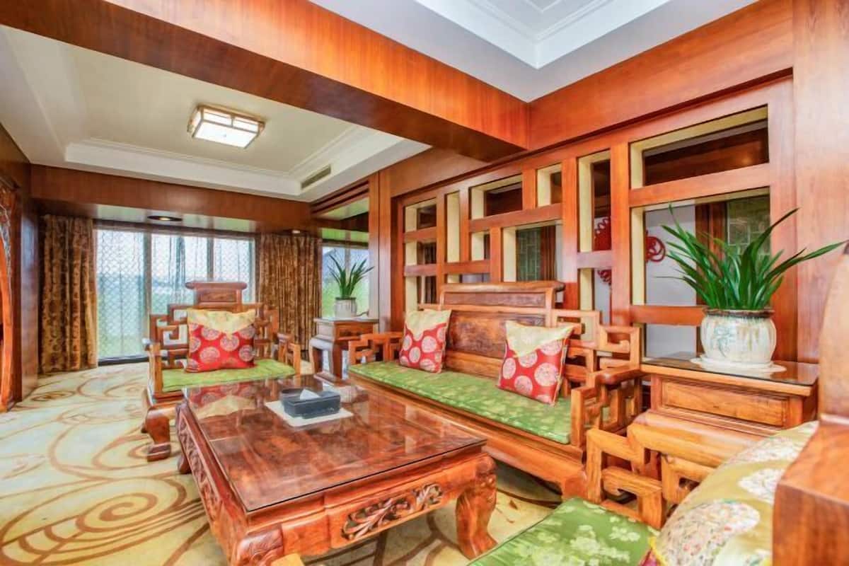 Une pièce traditionnelle en bois, comprenant un ensemble de canapés, une table basse et un vase décoratif.