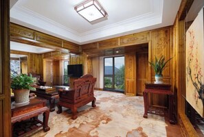 Una habitación amplia con paneles de madera, un gran ventanal y una televisión de pantalla plana.