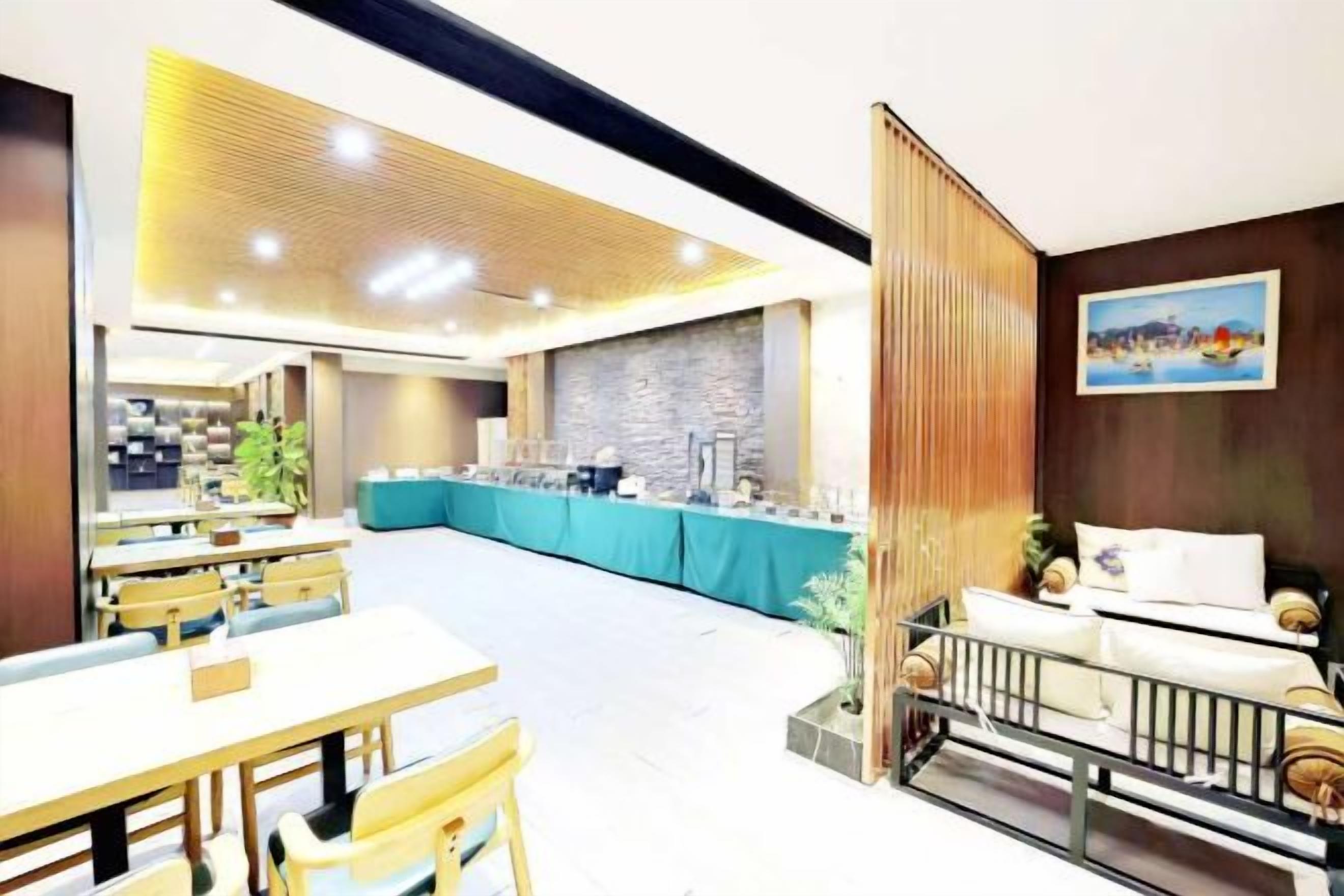 A hotel lobby with a reception desk, seating area, and a buffet setup.
