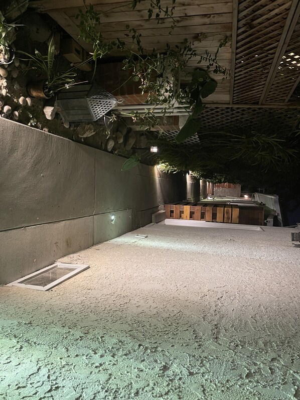 A narrow pathway flanked by a wooden fence and a white wall, leading to a building entrance. - Cute Tropical Beach Studio Walk to Ocean and All! (Long Beach)