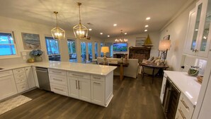 A modern kitchen with white cabinetry, a central island, and pendant lighting.